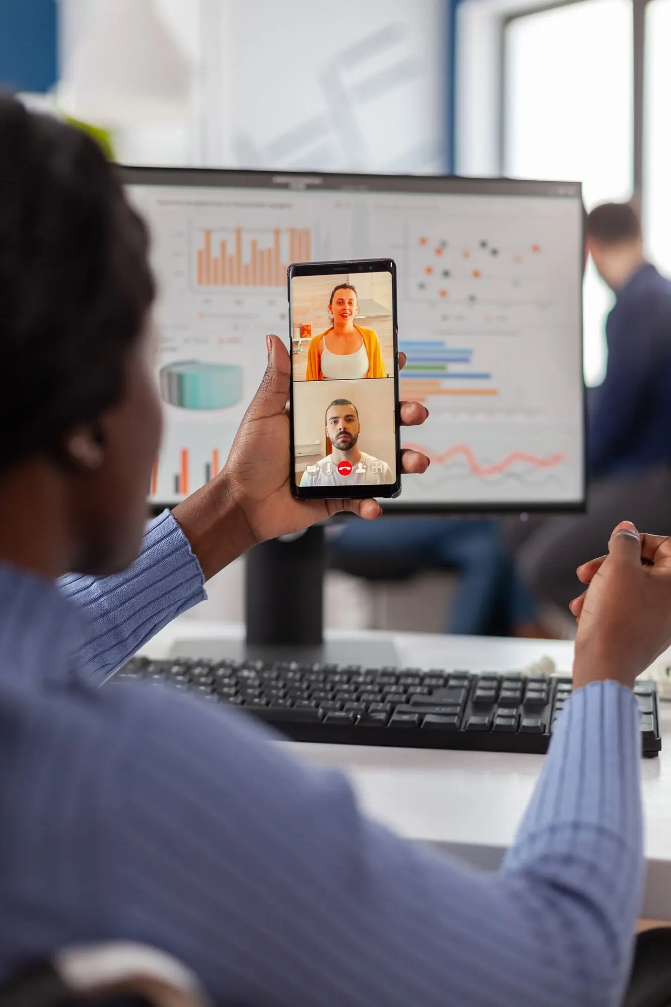 Менеджер с инвалидностью, работающий в финансовой компании, разговаривает с друзьями по видеосвязи, держа мобильный телефон.