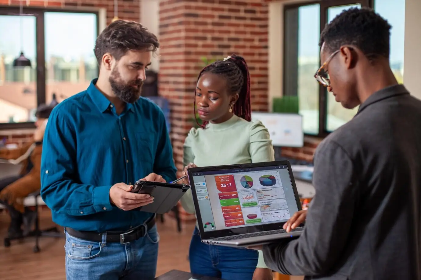 Коллеги используют цифровые устройства в офисе.